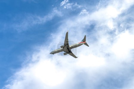 Foto de Miami, Florida - 25 de agosto de 2023: American Airlines vuela en cielo azul en un día soleado. Viajes, vacaciones, concepto de transporte aéreo. - Imagen libre de derechos