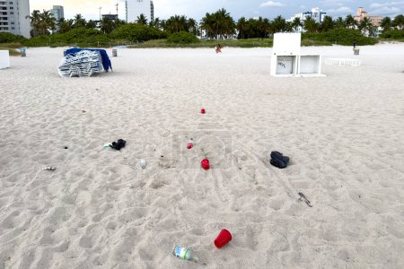 Téléchargez les photos : Miami, Floride - 25 août 2023 : Poubelles en plastique sur une plage avec la ville en arrière-plan à Miami, Floride. - en image libre de droit