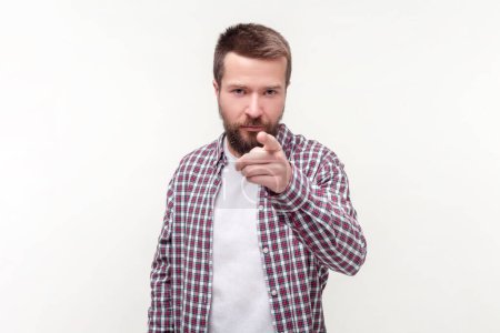 Photo for Portrait of strict serious bearded man pointing at camera choosing you bossy expression, wearing casual checkered shirt. Indoor studio shot isolated on gray background. - Royalty Free Image