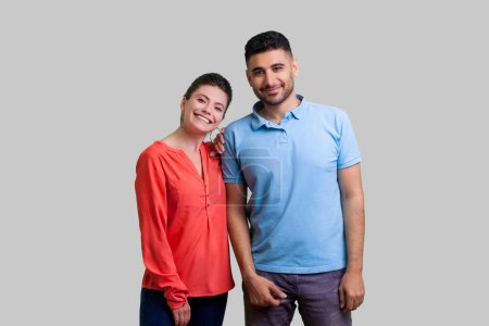Photo for Portrait of smiling positive couple man and woman standing together looking at camera expressing optimistic emotions. Indoor studio shot isolated on gray background. - Royalty Free Image