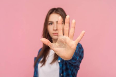 Photo for Portrait of strict brown haired woman showingstop gesture trying to stop bad relation loos upset, wearing checkered shirt. Indoor studio shot isolated on pink background. - Royalty Free Image