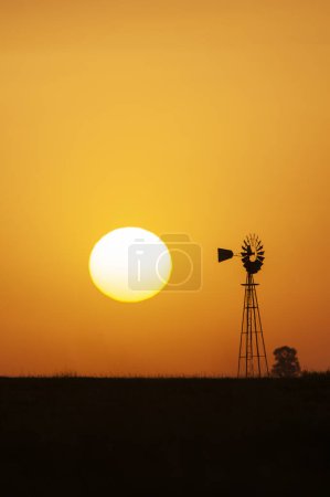 Téléchargez les photos : Moulin à vent à la campagne au coucher du soleil orange, Pampas, Patagonie, Argentine - en image libre de droit