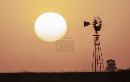 Windmill in countryside at orange sunset, Pampas, Patagonia,Argentina.