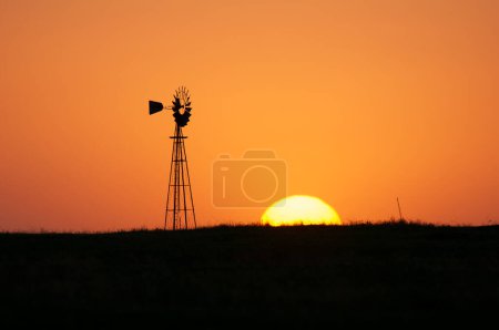 Windmill in countryside at orange sunset, Pampas, Patagonia,Argentina.