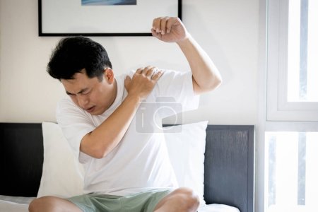 Photo for Asian middle aged man suffering from frozen shoulder,pain and stiffness,unable to move,difficulty lifting his arm,male people with calcific tendonitis or shoulder injuries,health care,medical concept - Royalty Free Image