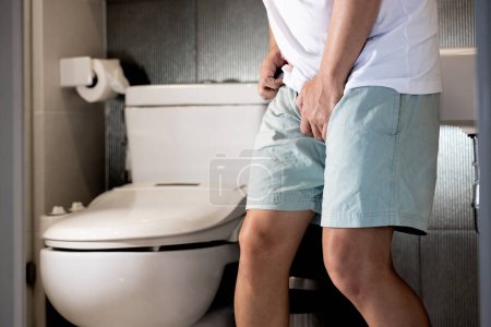 Sick asian middle aged man suffering from Sexually Transmitted Disease(STD),Gonorrhea,Genital Herpes,Venereal disease,inflammation of urethra,Male patient holding crotch,painful or difficult urination