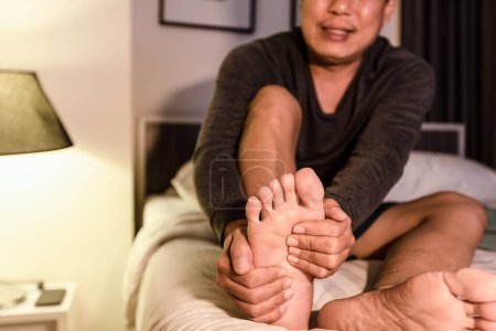 Téléchargez les photos : Asiatique homme d'âge moyen ont des crampes sévères son muscle mollet de la jambe, les hommes adultes souffrant de crampes du pied, problèmes de neuropathie périphérique, engourdissement ou faiblesse dans la jambe, béribérie dans les pieds et les orteils - en image libre de droit