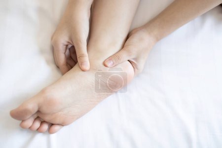 Hands of girl massage her foot,pain under ankle bone, disease of Flat Foot,inflammation of muscle and tendon between foot and ankle from Tibialis Posterior Dysfunction or Problem of Plantar Fasciitis