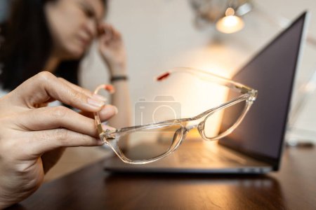 Foto de Mujer cansada sosteniendo malas gafas, problema de la prueba de agudeza visual o error de medición ocular inexacto, las mujeres usan gafas graduadas no estándar sufre tensión ocular, visión borrosa, concepto de gafas graduadas - Imagen libre de derechos