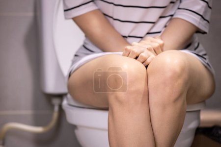 Photo for Asian woman urinating in toilet,problem of Polyuria,urination disorders,frequent micturition,urinary incontinence,urinary urgency,overactive bladder,urine frequency,kidney and urinary bladder system - Royalty Free Image