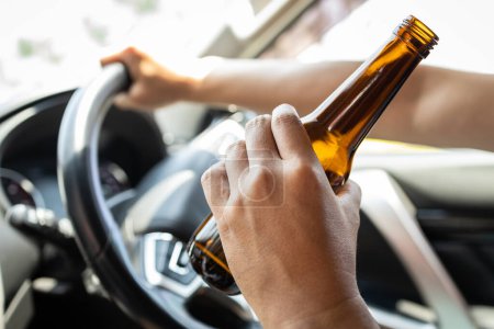 Téléchargez les photos : Homme ivre conducteur tenant une bouteille de bière, homme asiatique buvant de l'alcool en conduisant un véhicule à moteur, risque ou danger d'accidents de la route, ne pas boire et conduire, prévention, réduction des victimes d'accidents de la route - en image libre de droit
