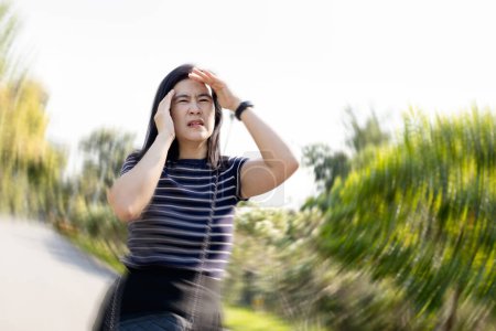Dizzy woman suffering from vertigo,sensation of whirling,spinning around,loss of balance,she walked with stagger,vertigo while walking outdoor,symptom of giddiness,dizziness attack,health care concept