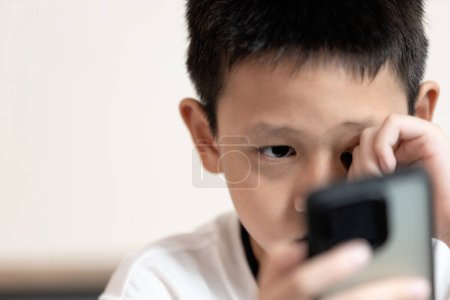 Enfant garçon regardant écran de téléphone, incapable de voir clairement, maladie d'Amblyopie, vision trouble ou symptômes de myopie, astigmatisme, troubles de la vue, problèmes de vue, rétinopathie, inflammation de la rétine
