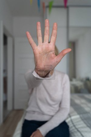Foto de Mujer mostrando gesto de alto con la mano en casa. Abuso, salud mental, problemas de relación tóxica. Foto de alta calidad - Imagen libre de derechos