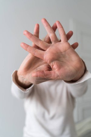 Mujer mostrando gesto de alto con la mano en casa. Abuso, salud mental, problemas de relación tóxica. Foto de alta calidad