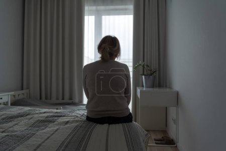Photo for Mature woman sitting alone in the room, sad depressed person. Back view. mental health problemageing population. High quality photo - Royalty Free Image