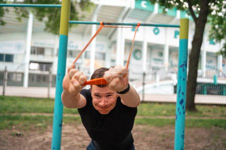 Photo for Middle age man doing strength exercises with resistance bands outdoors in park . High quality photo - Royalty Free Image
