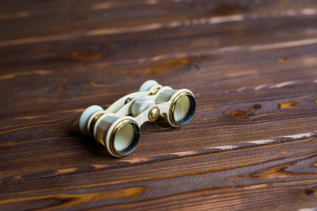 Photo for Ivory opera glasses dark wooden background. Theatrical binoculars. - Royalty Free Image