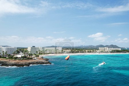 Téléchargez les photos : Les touristes profitent de parasailing à Sa Coma plage à Majorque, Espagne sur une journée d'été - en image libre de droit