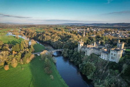 Photo for Aerial view of majestic Lismore Castle in County Waterford, Ireland, bathed in the golden glow of the setting sun on the first day of spring, showcasing its timeless beauty and historic charm - Royalty Free Image