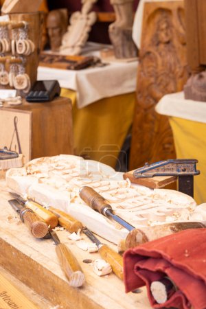 Ein Holzhandwerker, der eine Kostprobe seiner Arbeit während des Mittelaltermarktes in der Stadt El lamo (Madrid), Spanien, während des Tages Mai 