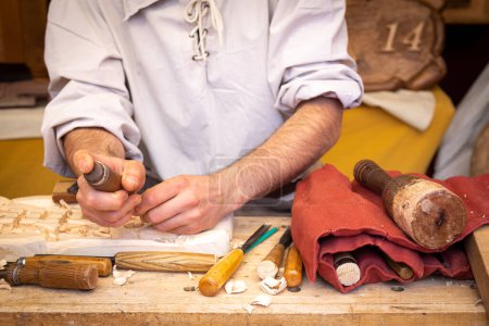 Korbflechter, der mit seinen Händen an der Herstellung von Körben arbeitet. Nahaufnahme, aufgenommen während der Feier des Mittelaltermarktes in der Stadt El Alamo (Madrid) am Wochenende des 4. Mai 2024