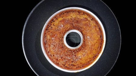 Indonesian Local Caramel Cake on the Silver pan with Isolated Black Background. Top view. Flat Lay.