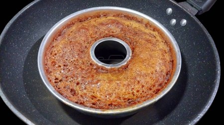 Indonesian Local Caramel Cake on the Silver pan with Isolated Black Background.