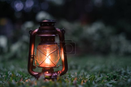 Téléchargez les photos : Lampe à huile antique Sur l'herbe dans la forêt dans l'atmosphère de camping du soir.Travel Outdoor Concept image - en image libre de droit