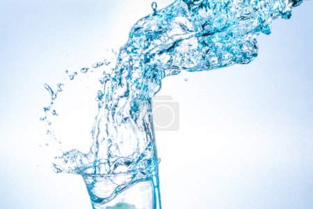 Photo for Drinking water splashing from the glass on white background - Royalty Free Image