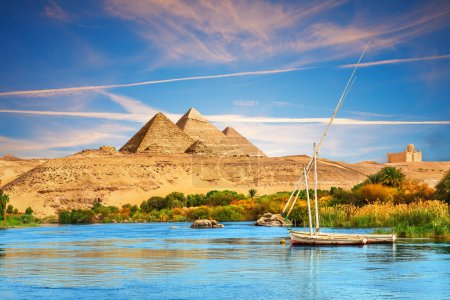 View on the Nile and the boats in the Aswan desert by the pyramids, Egypt.