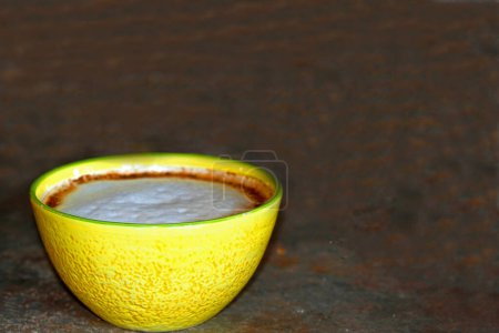 Foto de Coffee latte with foam abd cinnamon in yellow bowl - Imagen libre de derechos