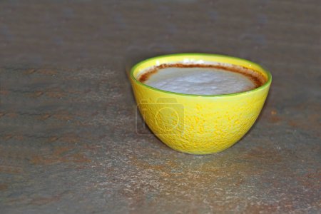 Foto de Coffee latte with foam and cinnamon in yellow bowl - Imagen libre de derechos