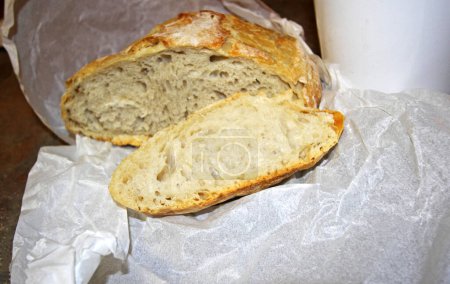 Foto de Sliced homemde bread with parchment paper wrapping - Imagen libre de derechos