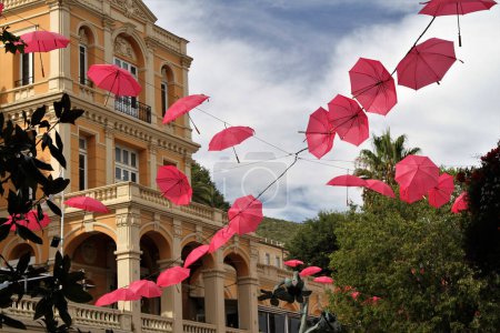 Foto de Ciudad a lo largo de Cote d 'Azur, Francia con sombrillas rosas colgantes - Imagen libre de derechos