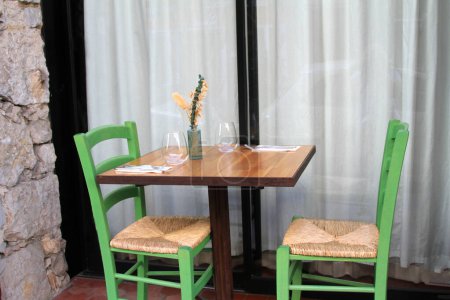 Foto de Conjunto de mesa exterior para comer con dos sillas verdes y asientos de ratán - Imagen libre de derechos
