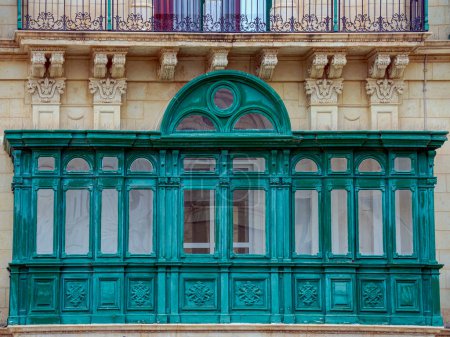 Photo for Fragment of the building's facade with traditional wooden ornate balconies painted in Valletta, Malta. - Royalty Free Image