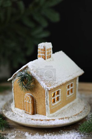 Téléchargez les photos : Belle maison en pain d'épice faite à la main pour Noël et le Nouvel An, fond sombre, mise au point sélective. Photo de haute qualité - en image libre de droit