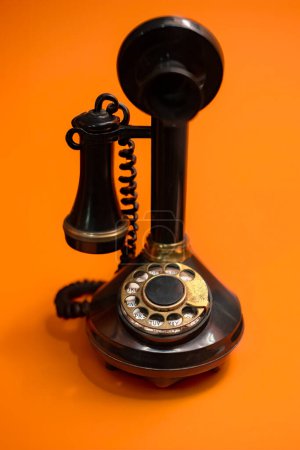 Photo for Vintage Rotary Dial Telephone on a Bright Orange Background - Royalty Free Image