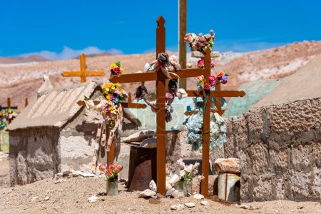 In der chilenischen Atacama-Wüste zieren bunte Kreuze und Blumen einen isolierten Friedhof rustikaler Gräber.