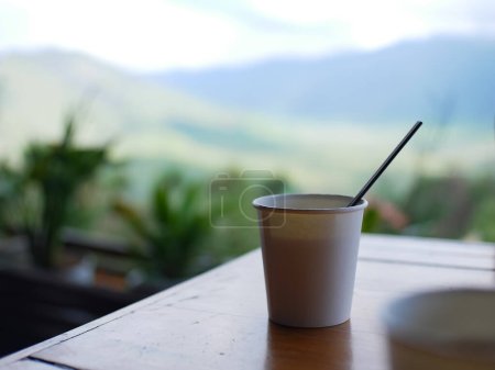 Tasses à café en papier photographiées avec la toile de fond du mont Bromo au loin. concept de café dans les zones montagneuses