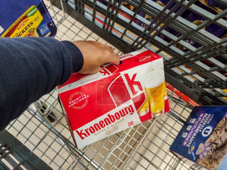 Photo for Puilboreau, France - October 14, 2020:Close up on customer putting a pack of Kronenbourg beer in their shopping cart at the supermarket - Royalty Free Image