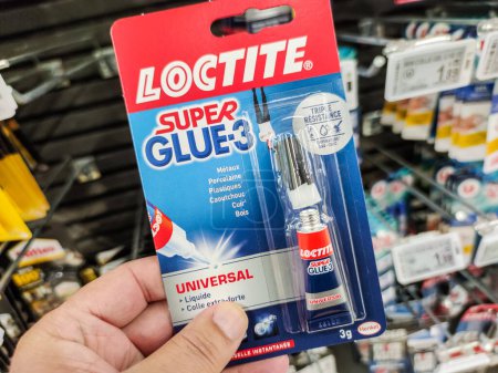 Photo for Puilboreau, France - October 14, 2020:Customer holding Quick-Drying Glue "Loctite" brand in a French Hardware Store - Royalty Free Image