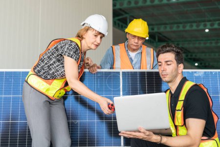 Téléchargez les photos : Equipe d'ingénieurs et d'architectes travaillant sur un panneau solaire dans une centrale solaire. - en image libre de droit