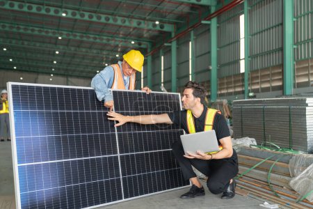 Téléchargez les photos : Travailleur et ingénieur vérifiant panneau solaire dans l'entrepôt. Ceci est un entrepôt de transport et de distribution de fret. - en image libre de droit