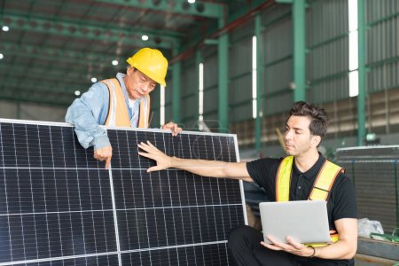 Téléchargez les photos : Ingénieur et technicien travaillant ensemble dans une centrale solaire. Ceci est un entrepôt de transport et de distribution de fret. - en image libre de droit