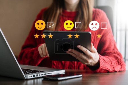 Foto de Concepto de evaluación del servicio al cliente. Mujer de negocios presionando emoticono sonrisa cara y el uso de la tableta digital - Imagen libre de derechos