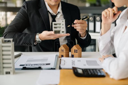 Foto de Considering buying a home, investing in real estate. Broker signs a sales agreement. agent, lease agreement, successful deal. at office - Imagen libre de derechos