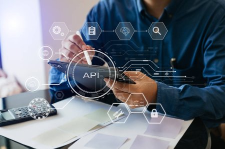 Foto de API - Application Programming Interface, man using tablet and smartphone with virtual screen API icon Software development tool, modern technology and networking concept - Imagen libre de derechos