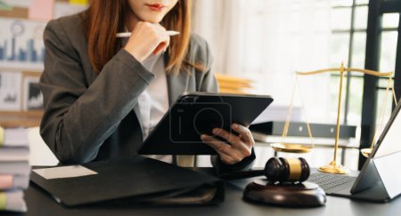 Photo for Justice and law concept.Male judge in a courtroom  the gavel, working with tablet on black table - Royalty Free Image